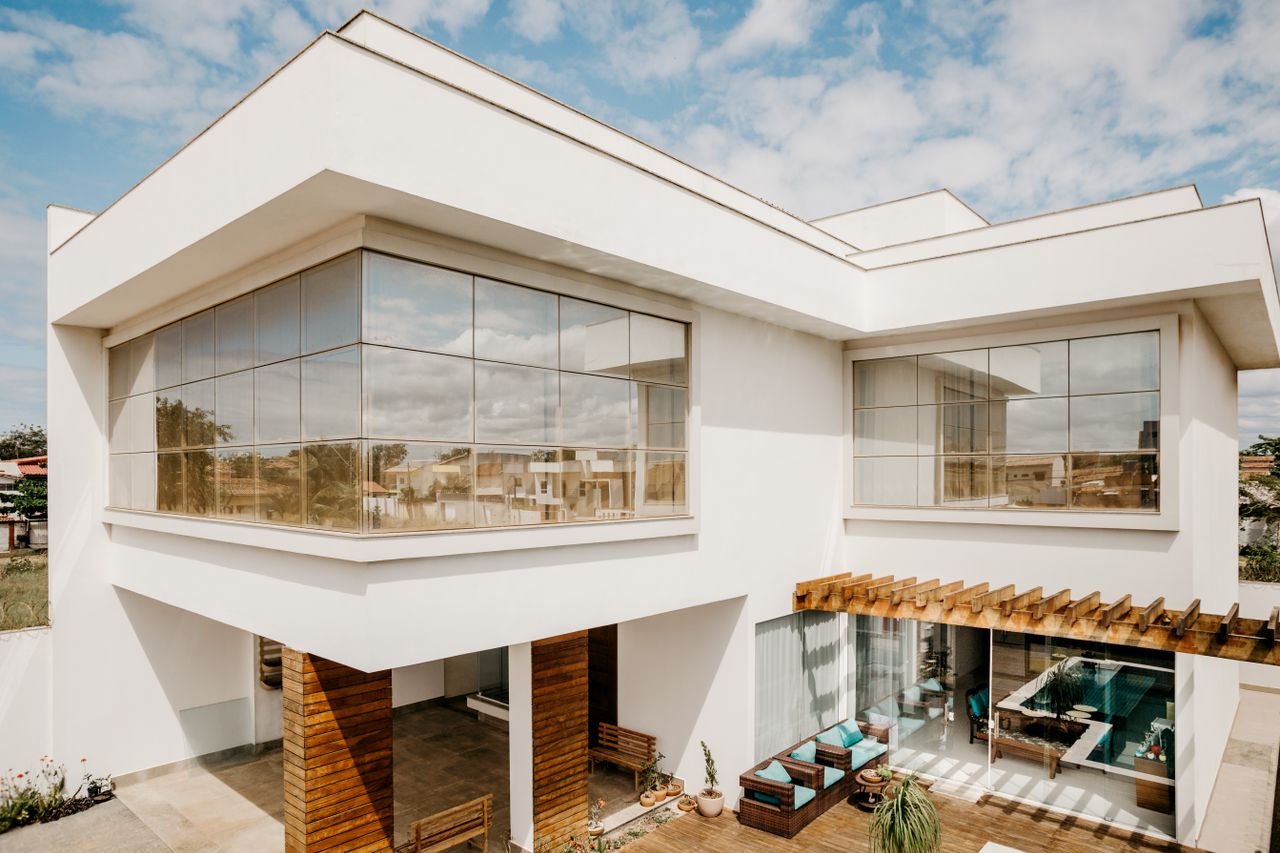 cta-bg Exterior of contemporary cottage with large windows and stylish terrace against cloudy blue sky