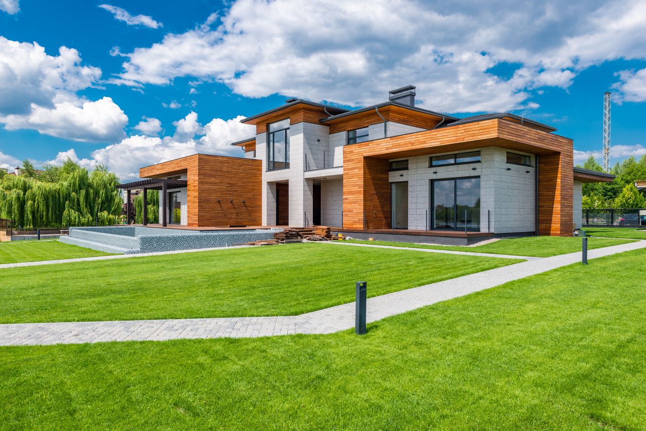 services-02 Exterior of contemporary residential house with green yard and paths near forest in summer